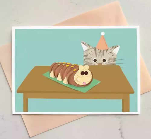 birthday card featuring a cat looking up at a caterpillar cake.