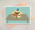 birthday card featuring dog looking up at a cateprillar cake