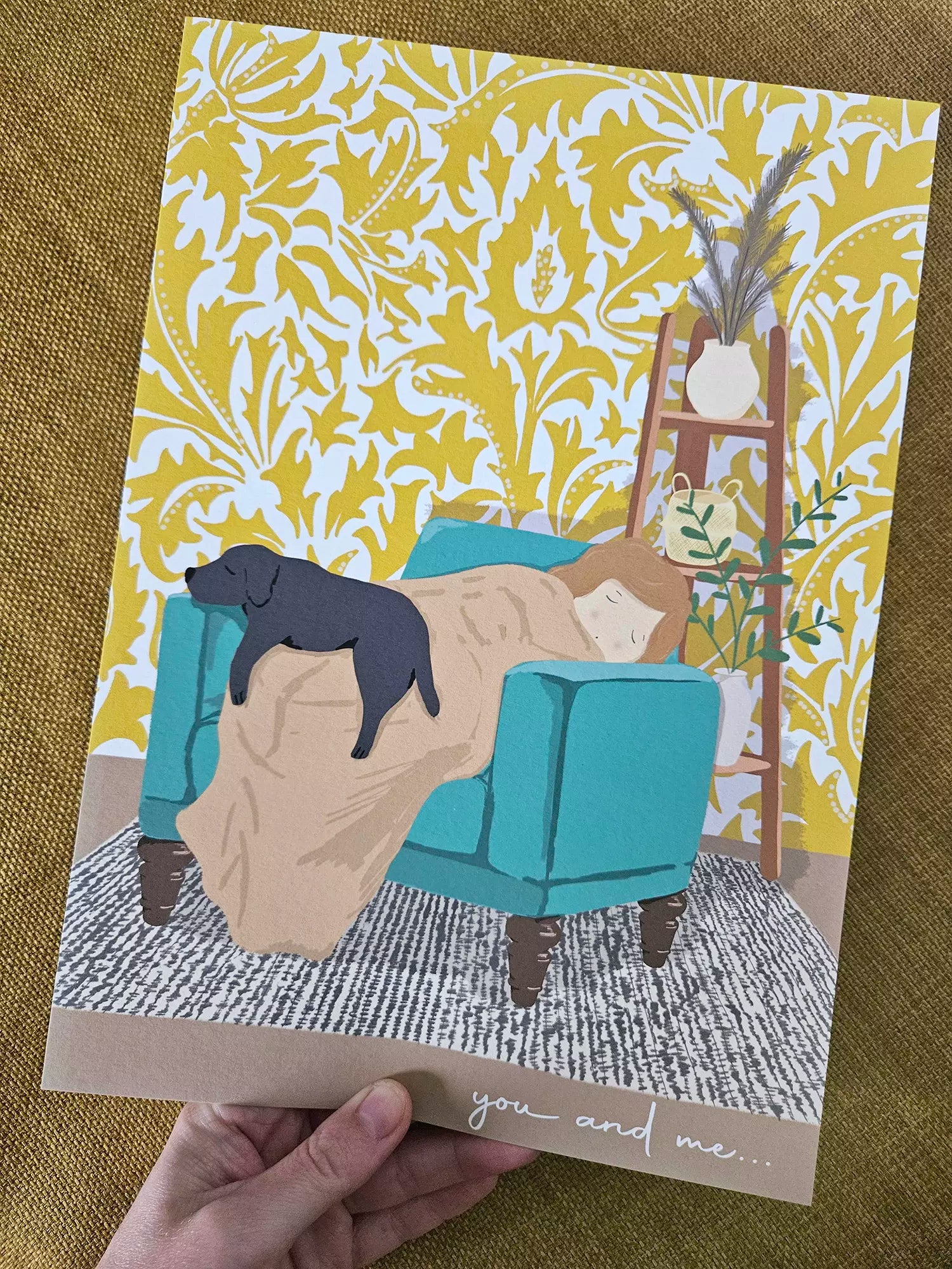 Illustrated print with dog and owner sleeping in armchair and patterned wallpaper background